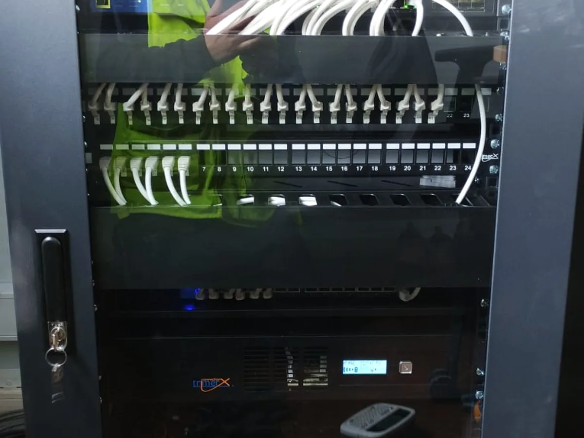 Técnico de SC Informática trabajando en un rack de comunicaciones